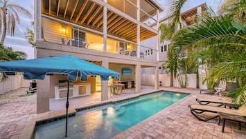 The pool glows at twilight, its Baja shelf perfect for lounging with a drink as the home's balconies light up above.