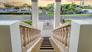 A staircase leading to a covered area with a view of a residential street and houses. - 🌴 Island Escape | Home on Siesta Key w/ Private Heated Pool & Ping Pong Table! (Siesta Key)