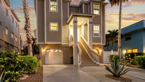 A two-story house with a front entrance, a staircase, and a garage. - 🌴 Island Escape | Home on Siesta Key w/ Private Heated Pool & Ping Pong Table! (Siesta Key)
