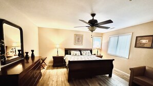 A bedroom with a bed, a ceiling fan, a dresser, a chair, and a window with blinds. - Spacious & Modern with Workspace - A+ Location!!! (Mooresville)