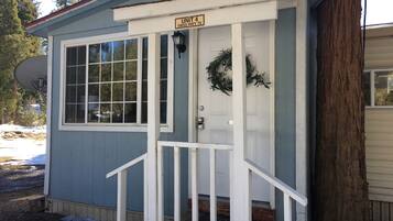 A small, single-story building with a white door and a sign above it that reads "UNIT 4 59655 HWY 70".