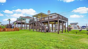 Ein zweistöckiges Holzhaus mit Balkon, Treppe und umzäunter Garten.