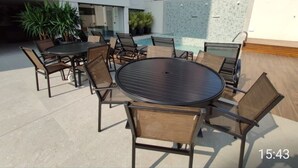 A bedroom with a bed and built-in drawers, and a balcony with a pool table and chairs. - Charming apartment (PR)