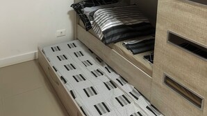 A bunk bed with a mattress, pillows, and a shelf unit. - Charming apartment (PR)
