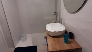 A modern bathroom with a white sink, a mirror, and a shower. - MARINE SENATOR (Costa Teguise)