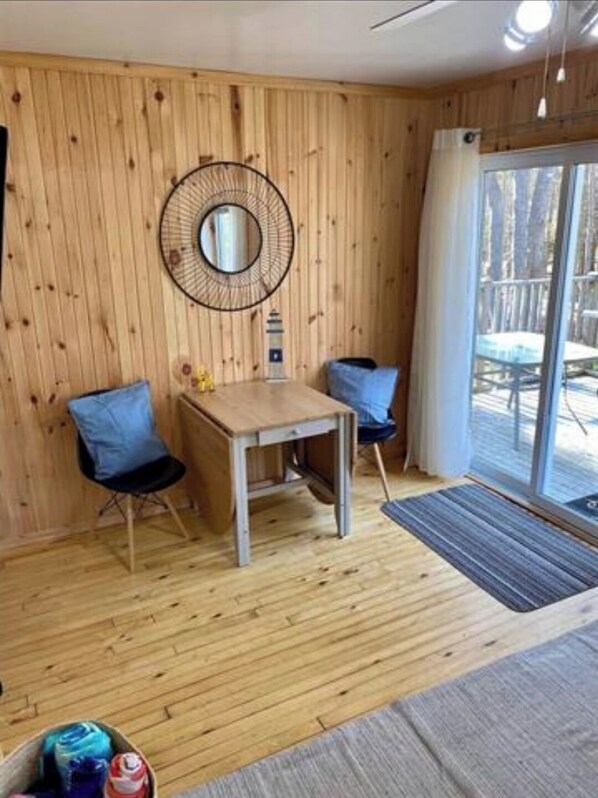 Relax in this inviting room with a view, featuring a large window, comfortable seating area, and a stylish mirror.