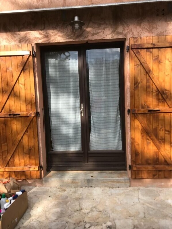 Uma porta de madeira com moldura escura e cortina clara.