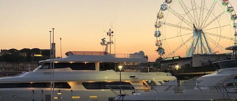Un puerto deportivo con yates amarrados, una noria al fondo y el texto "CANNES" que indica la ubicación.