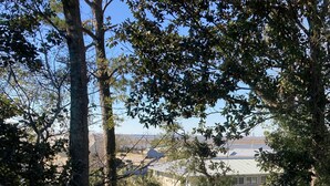 A view from a balcony with a railing, overlooking a parking lot and buildings in the distance. - 2144 New Bayfront Condo overlooking Mobile Bay (Daphne)