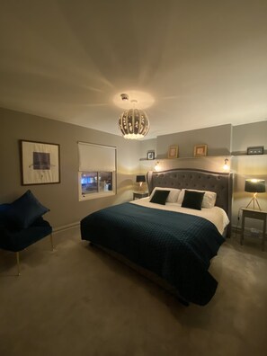 A bedroom with a large bed, a window, a chair, and a chandelier. - Luxury Apartment Beside The Cashel Palace Hotel (Cashel)