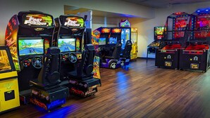 A row of arcade racing games with "The Fast and the Furious" theme, including "Burnout" and "Need for Speed" titles. - The Foothills Motel (Auburn)