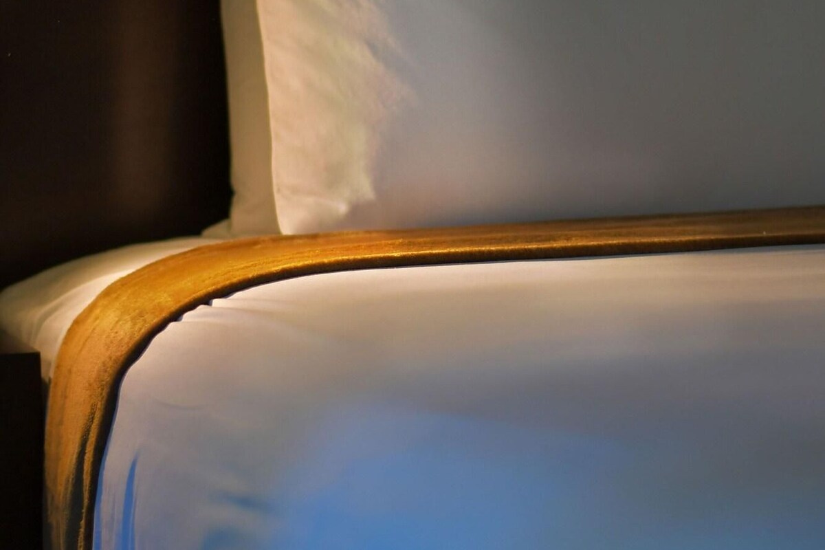A bed with white bedding and a wooden headboard.