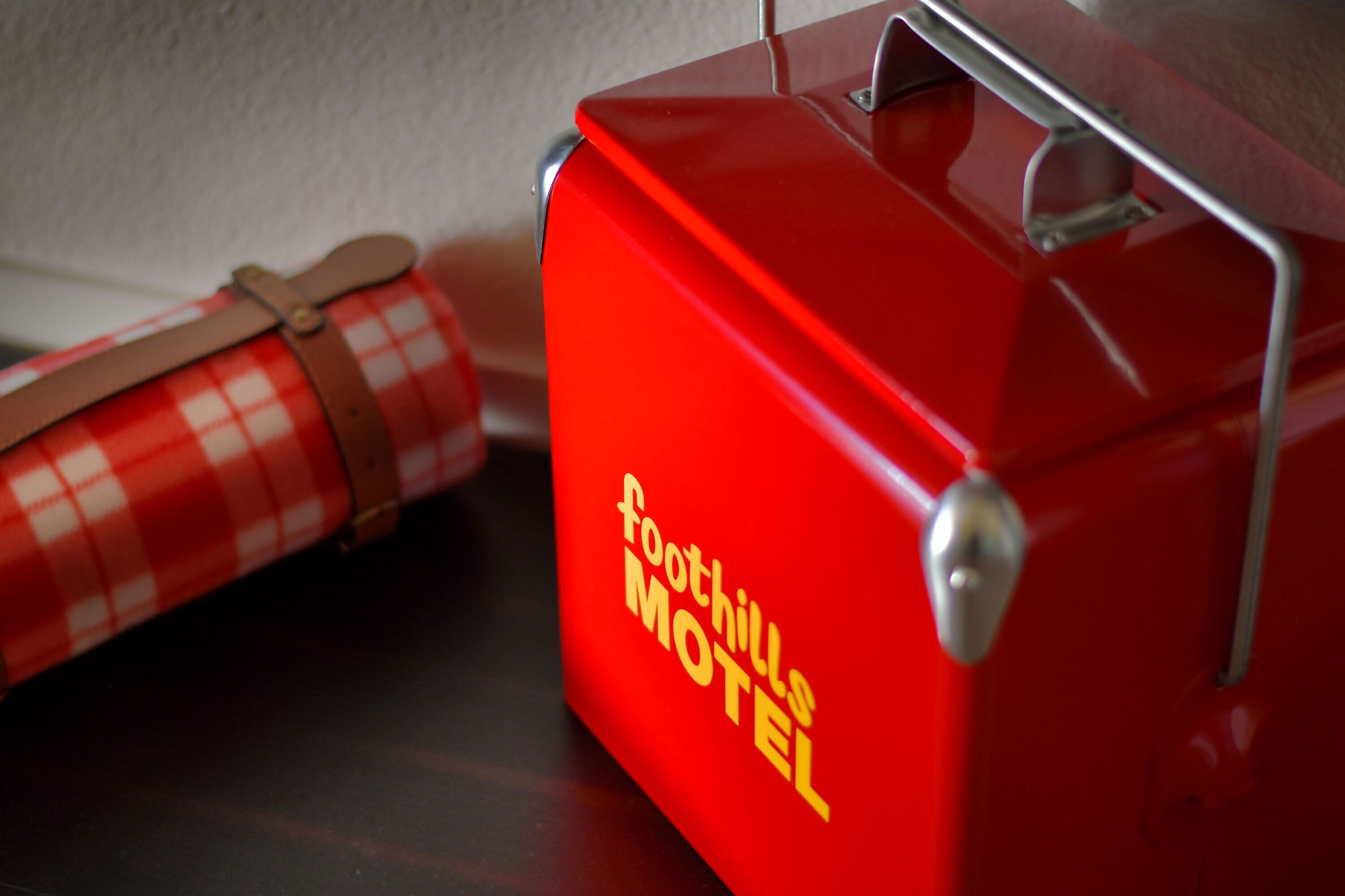 Una maleta roja con el texto "foothills motel".