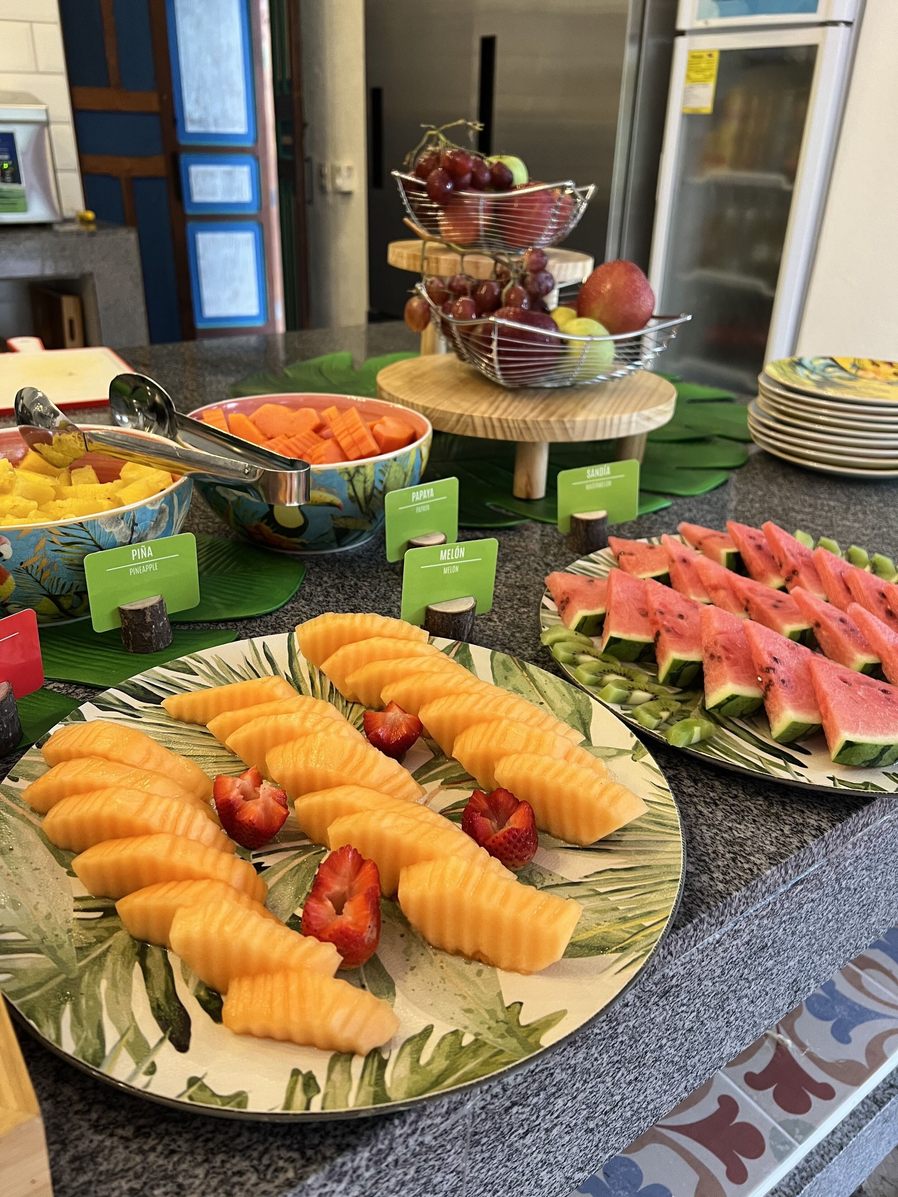 A buffet with various fruits and vegetables, including pineapple, papaya, and watermelon.