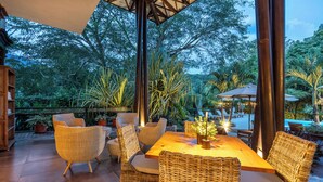 An outdoor dining area with wicker furniture, a wooden table, and potted plants. - Casa Jacaranda Hotel Boutique - Cauca Viejo - Mayores de 14 años (Jericó)