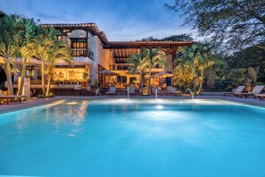 A poolside area with lounge chairs, a bar, and a building with a tiled roof and multiple levels. - Casa Jacaranda Hotel Boutique - Cauca Viejo - Mayores de 14 años (Jericó)
