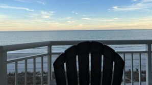A chair facing a beach with a railing, overlooking the ocean. - HS-0507 Oceanfront 1-BR Condo in Myrtle Beach, 652 sq ft of coastal comfort for up to 6 guests. (Myrtle Beach)