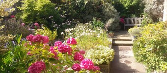 Central holiday home with pretty, sunny garden, moments from the station, golf course and beach.
