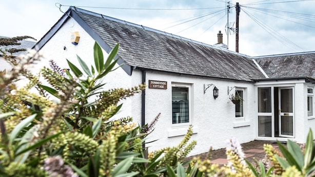 A white cottage with a sign reading "Sommerside Cottage." - A delightful, homely cottage.  A great base for all of East Lothian. Sleeps 4. (Gullane)