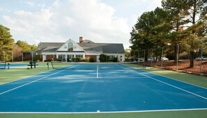 Enjoy a game of tennis on the adjacent court, surrounded by trees and a charming residential setting.