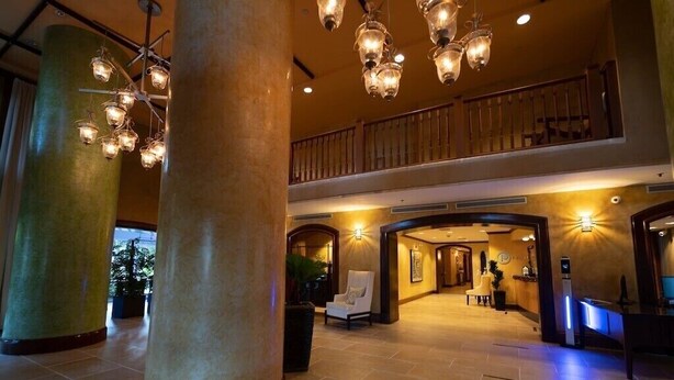 A spacious lobby with large columns, a reception desk, and a staircase leading to an upper level. - Your Bay View Escape in Coconut Grove, Pool & Gym (Miami)