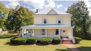 A two-story house with a porch and a front yard.