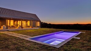 Una casa moderna con piscina al atardecer.