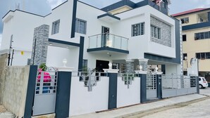 A modern two-story house with a balcony, a gated entrance, and a visible driveway. - 5 minutes from la caleta beach 10 minutes from casa de campo la romana (romana del este)