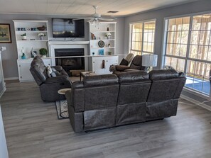 Relax in this stylish living room with a large leather sofa, flat-screen TV, and cozy fireplace.