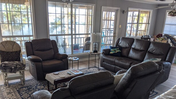 A living room with a large window, a sofa, a recliner, and a coffee table. - Toledo Bend on Lanana Bay Waterfront Camp Boathouse Dock Subdivision Boat Launch (Many)