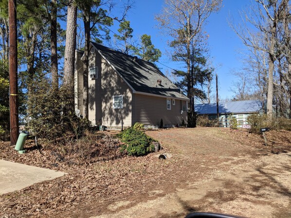 Standalone house surrounded by mature trees and a well-maintained lawn.