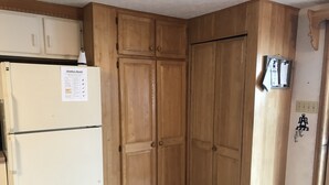 Una cocina con armarios de madera, un refrigerador blanco y un aviso en el refrigerador.