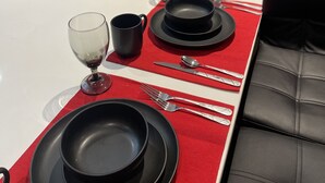 A dining area with a red table runner, black plates, and silverware. - Mr. Whips Family Fun House 3,000 Sq Ft Game unit with arcade room and rear yard (Philadelphia)