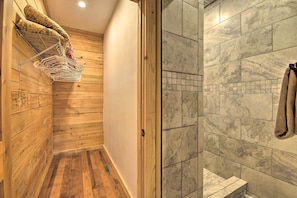 Relax in a bathroom with a wooden interior, featuring a shower area with a bench and a towel rack.