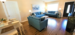 A living room with a blue sofa, a coffee table, and a lamp.