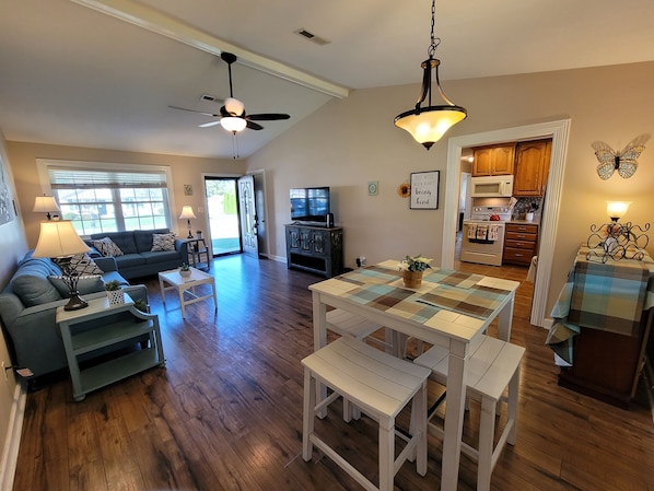 A spacious living area with a sofa, coffee table, and a dining table with benches.