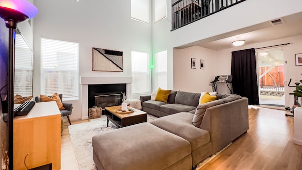 A spacious living room with a fireplace, a sofa set, a coffee table, and a TV. - Friends, Family & Dog Stay in Monterey Peninsula with AC & Grill (Salinas)