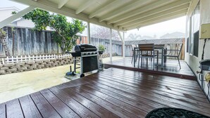 A covered patio with a grill, outdoor furniture, and a view of the backyard. - Friends, Family & Dog Stay in Monterey Peninsula with AC & Grill (Salinas)