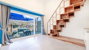 Ein modernes Interieur mit einer großen Schiebeglasdoor, die zu einer Terrassenauslässt, einer Holztreppe mit offenen Regalen und einem minimalistischen Design.