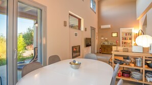 A modern kitchen with a dining area, a built-in oven, and a bookshelf. - Villa Aphrodite:Pet-friendly, 3 bedrooms,pool, WiFi, mobility-friendly (Poulades)