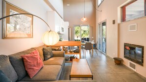 A modern living room with a sofa, coffee table, and a dining area with chairs and a table. - Villa Aphrodite:Pet-friendly, 3 bedrooms,pool, WiFi, mobility-friendly (Poulades)