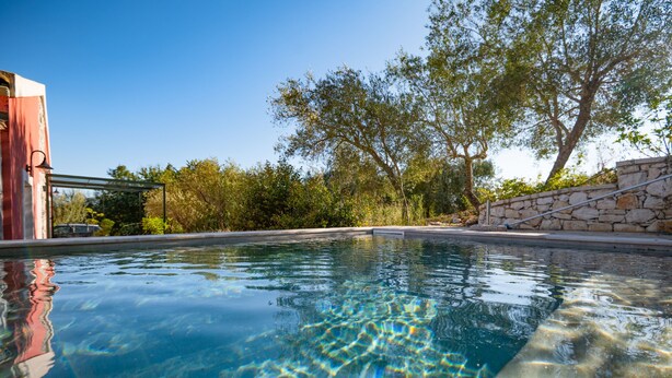 A clear swimming pool with stone walls and a pergola structure. - Villa Aphrodite:Pet-friendly, 3 bedrooms,pool, WiFi, mobility-friendly (Poulades)