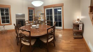 A dining area with a round wooden table, six chairs, and a chandelier. - Gorgeous newer home on Newton Lake/Crystal Lake near Elk mountain ski resort.  (Greenfield Township)