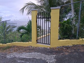 Una entrada tancada amb un mur groc i una reixa metàl·lica.