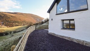 A house with a white exterior, large windows, and a gravel driveway. - Tyn Llwyn Barn (Corwen)