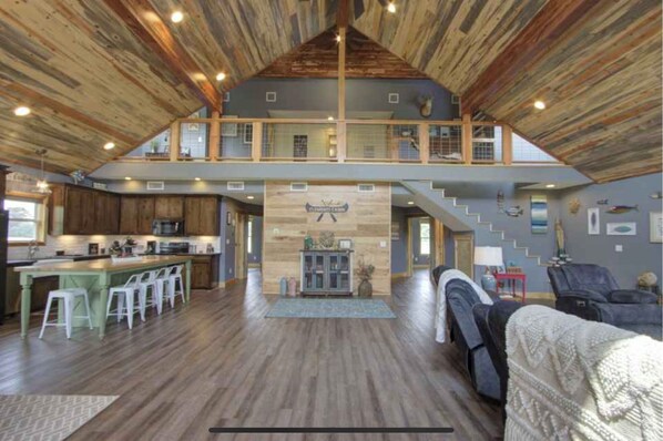 Experience the open and airy atmosphere of this multi-level space, featuring a balcony with a view and a kitchen area with bar stools and dining table.