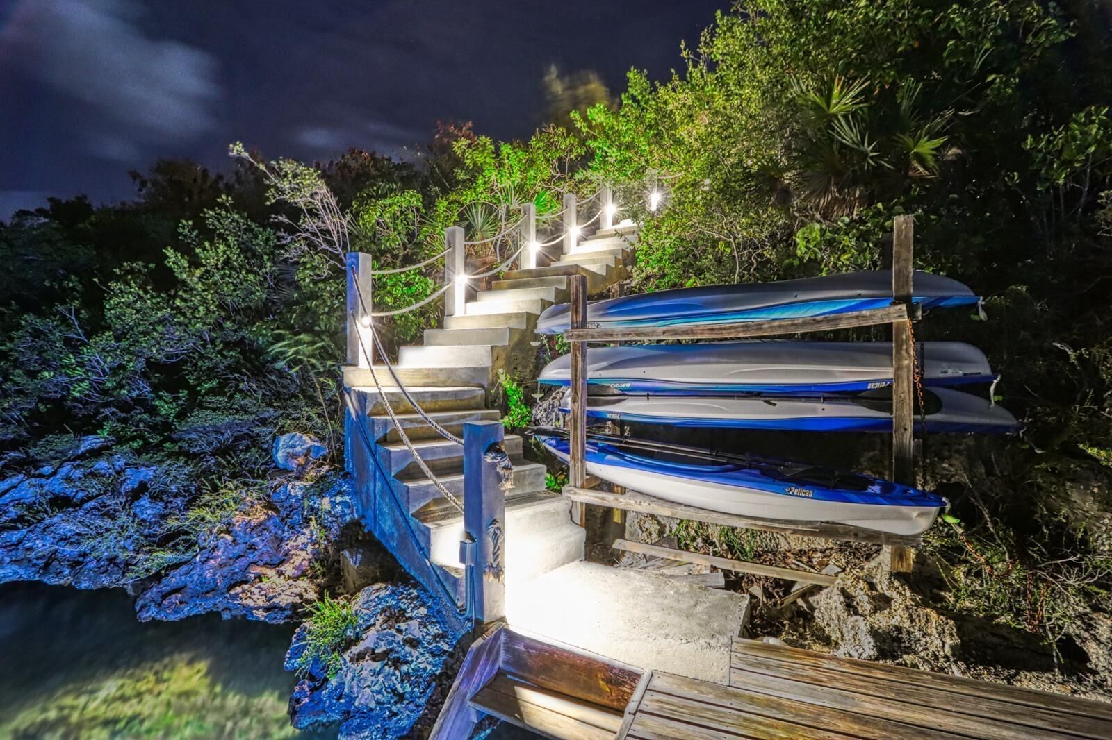 A wooden staircase leading to a dock with kayaks.