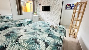A hotel room with two beds, a TV, a wooden ladder, and a marble wall. - Ponta dos Corais (Guarujá)
