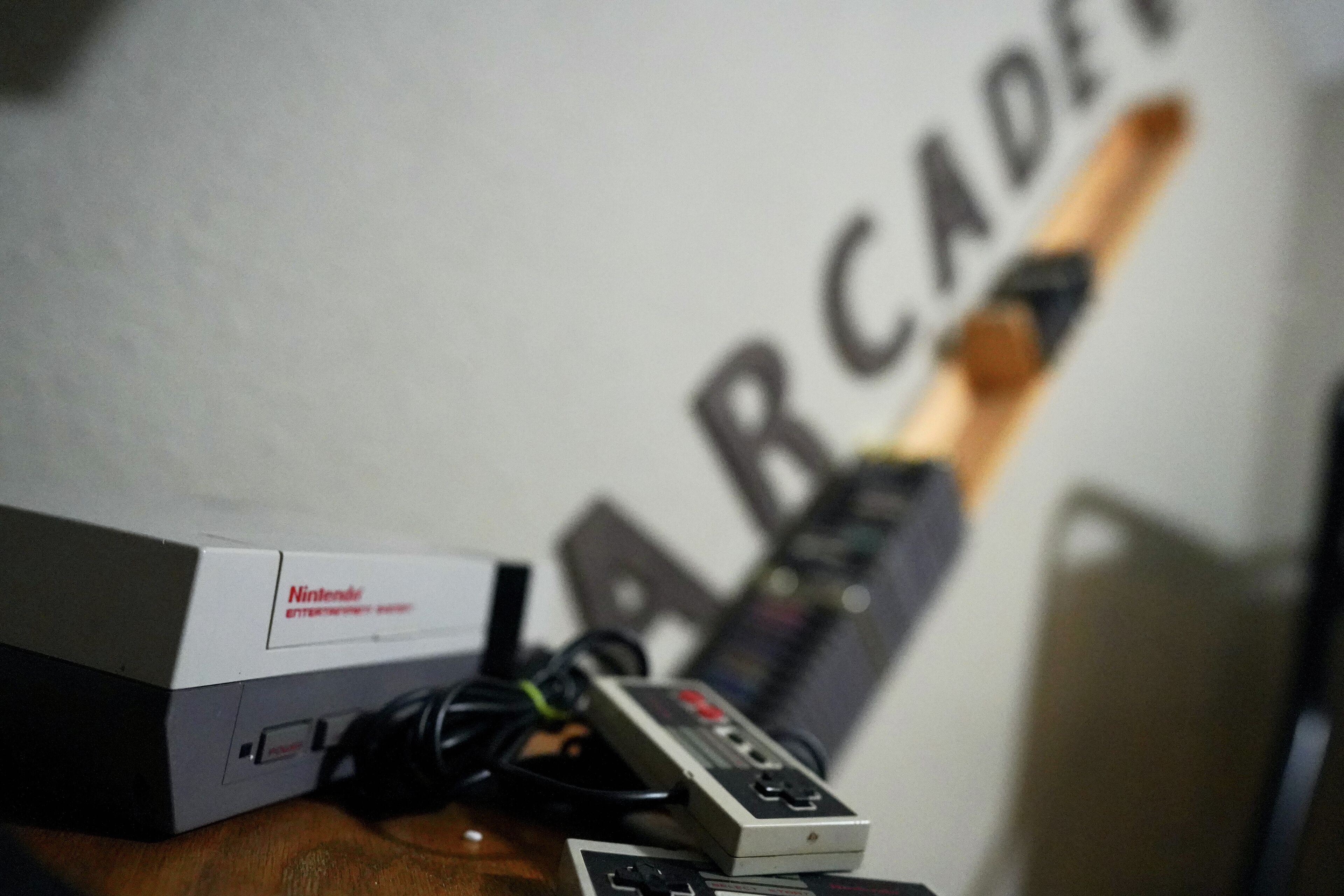 A Nintendo Entertainment System (NES) console and accessories on a wooden table.