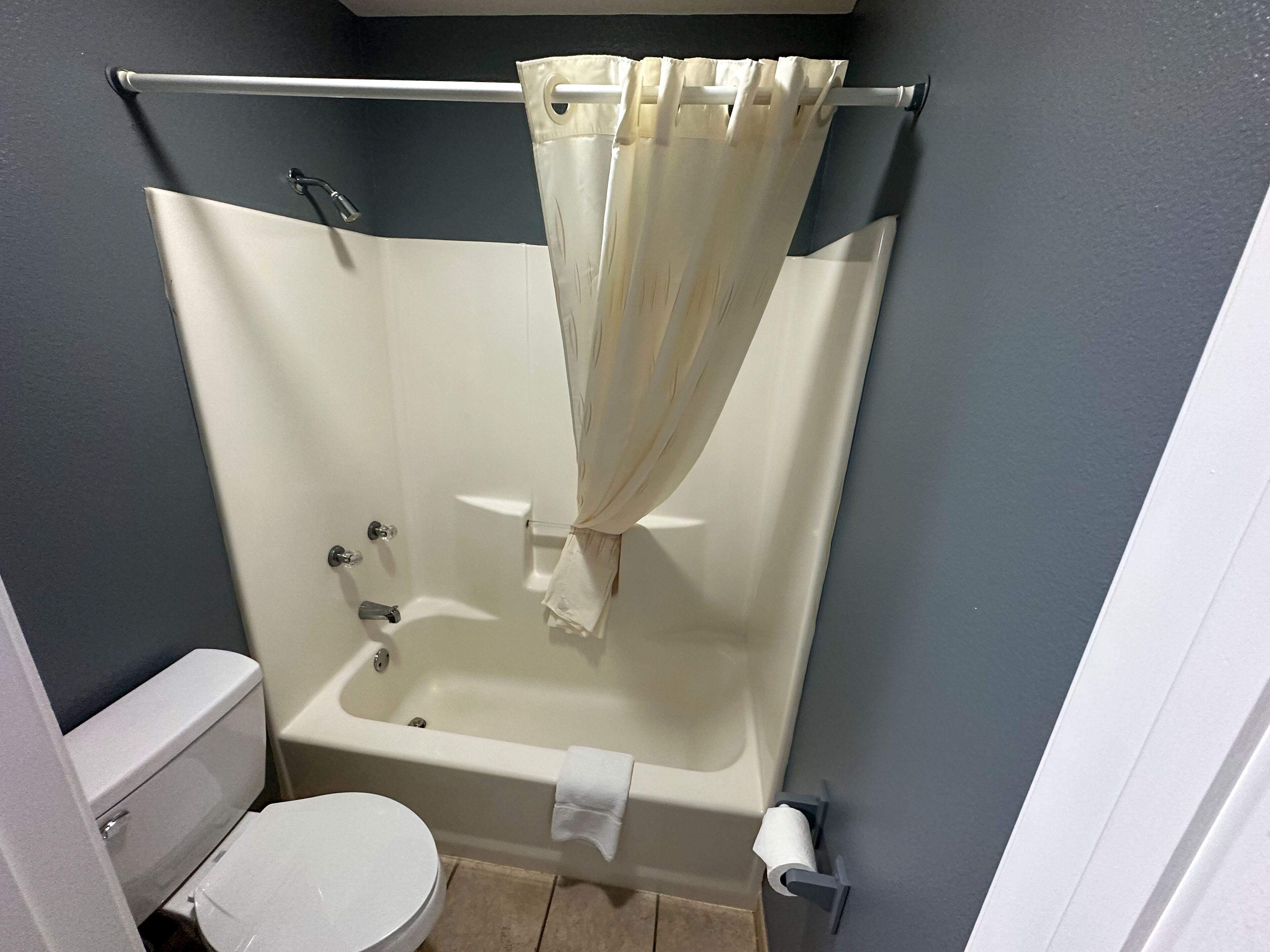 Ein kleines Badezimmer mit Badewanne, Toilette und Duschvorhang.